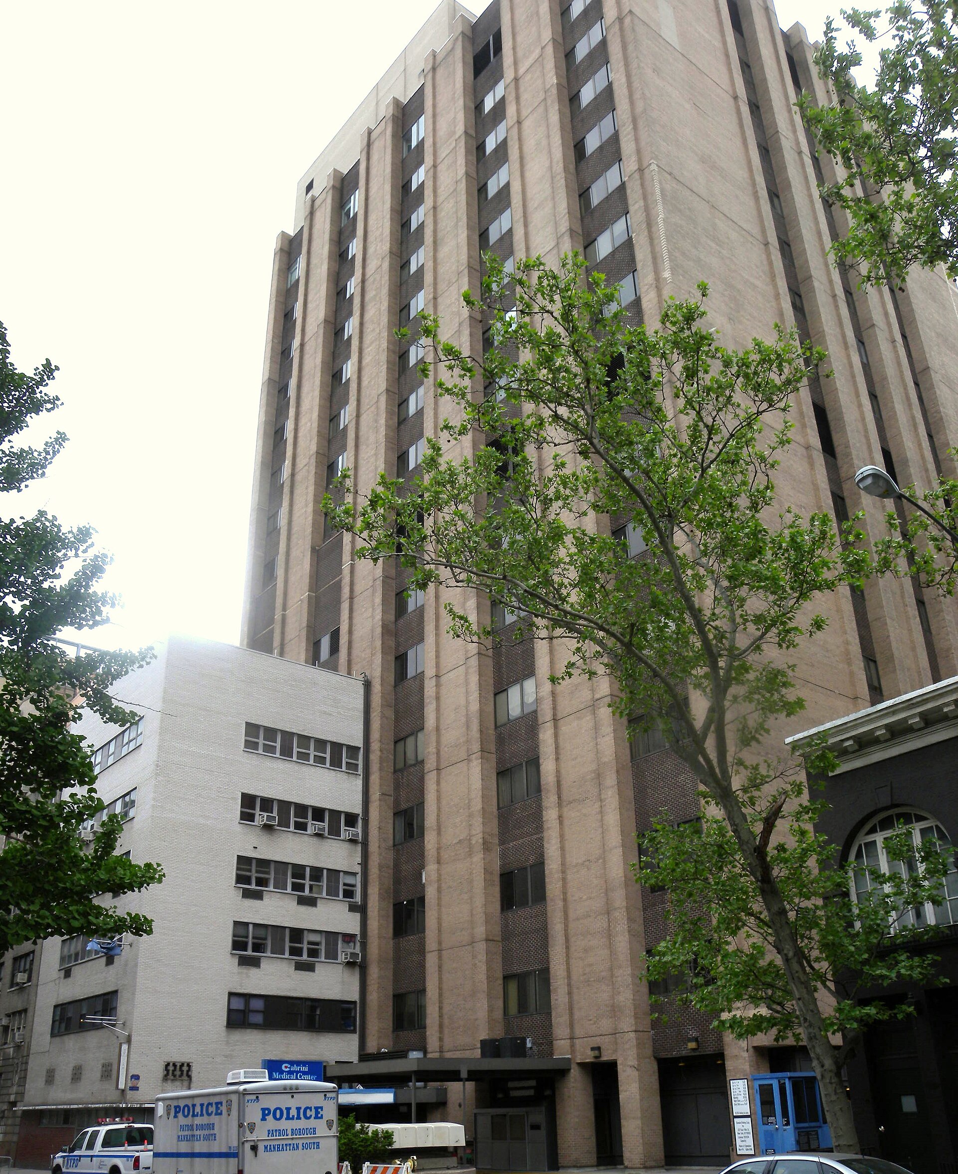 Columbus Hospital / Cabrini Health Care Center — annex completion and merger phase — Looking south across 20th Street at back side of closed Cabrini Medical Center on a cloudy afternoon. Photographed in 2011; a current view, not a construction-period photograph.